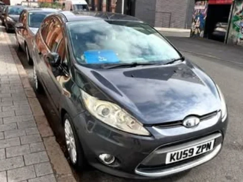 Black 2009 Ford Fiesta parked outside the garage